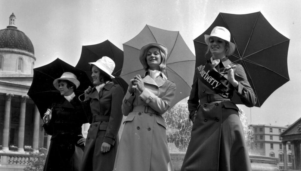 BURBERRY-MODELLER: Brenda Capwell, «Miss Burberry», poserer på Trafalgar Square i London sammen med tre andre modeller i Burberry-trenchcoater i mai 1970. BURBERRY-MODELLER: Brenda Capwell, «Miss Burberry», poserer på Trafalgar Square i London sammen med tre andre modeller i Burberry-trenchcoater i mai 1970.